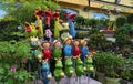 Detailed view of different ceramic figurines for garden decoration. Floral shop with blooming flowers in the pots in front