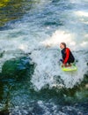 MUNICH, GERMANY, AUGUST 20, 2015: group of surfers is practicing their skill on an artificial wave situated on a small Royalty Free Stock Photo