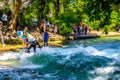 MUNICH, GERMANY, AUGUST 20, 2015: group of surfers is practicing their skill on an artificial wave situated on a small Royalty Free Stock Photo