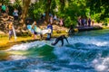 MUNICH, GERMANY, AUGUST 20, 2015: group of surfers is practicing their skill on an artificial wave situated on a small Royalty Free Stock Photo