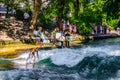 MUNICH, GERMANY, AUGUST 20, 2015: group of surfers is practicing their skill on an artificial wave situated on a small Royalty Free Stock Photo