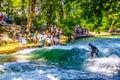 MUNICH, GERMANY, AUGUST 20, 2015: group of surfers is practicing their skill on an artificial wave situated on a small Royalty Free Stock Photo