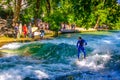 MUNICH, GERMANY, AUGUST 20, 2015: group of surfers is practicing their skill on an artificial wave situated on a small