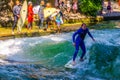 MUNICH, GERMANY, AUGUST 20, 2015: group of surfers is practicing their skill on an artificial wave situated on a small Royalty Free Stock Photo
