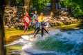 MUNICH, GERMANY, AUGUST 20, 2015: group of surfers is practicing their skill on an artificial wave situated on a small Royalty Free Stock Photo