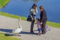 Munich, Germany - 10 17 2012: Girl teases a swan in the park.