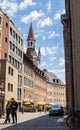 Munich, Germany - July 6, 2022: Cityscape of the old town MÃÂ¼nchen. Street view of narrow roads. The tower of the old town hall