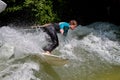 Munich, Germany - July 13, 2021: Surfer in the city river Eisbach. Munich is famous for surfing in urban enviroment