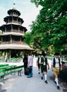 Traditionally dressed Bavarian men next to Chinese tower, Munich, Germany