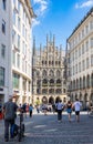 Munich, Germany - July 6, 2022: View through the alley of Rindermarkt up to Marienplatz with the new town hall. Tourists on the