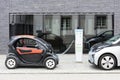 Munich, Germany- June 25, 2016: Two electric cars, Renault and BMW, being recharged at plug-in station in front of modern building Royalty Free Stock Photo