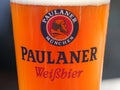 Munich, Germany - March 15, 2020: Close up of a wheat beer glass from the brewery Paulaner filled with delicious fresh