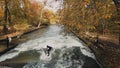 MUNICH, GERMANY, November 18, 2019: Real time wide shot of Urban Surfers on a wave on the Eisbach river. River Surfing