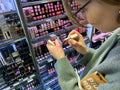Woman testing lipstick buysinbg in cosmetics store