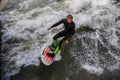 Munich, Germany - October 13, 2023: Surfer in the city river called Eisbach at Munich, Germany