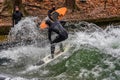 Munich, Germany - October 13, 2023: Surfer in the city river called Eisbach at Munich, Germany