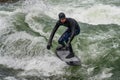 Munich, Germany - October 13, 2023: Surfer in the city river called Eisbach at Munich, Germany