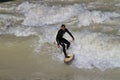 Munich, Germany - October 13, 2023: Surfer in the city river called Eisbach at Munich, Germany