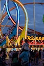 Munich, Germany - September 24: a father is carrying his young son on his shoulders in front of a 5 loop roller coaster on the