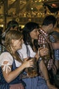 MUNICH, GERMANY - SEPTEMBER 18, 2016: Oktoberfest munich: 2 girls in traditional costumes drinking in the beer pavilion