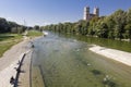 Munich, germany - 26 september 2016. people resting on the banks of the river isar on a sunny day. the tower of st. maximilian