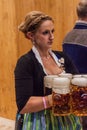 MUNICH, GERMANY - SEPTEMBER 17, 2016: Waitress carrying many beer glasses at the Oktoberfest in Muni