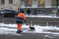 Municipal city service cleans footpath from snow after blizzard. Worker shoveling snow on sidewalk after snowfall. Working man. Royalty Free Stock Photo