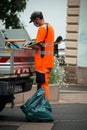 Municipal employee wearing orange vest working in the street
