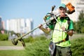 Municipal gardener landscaper worker with gas grass string trimmer