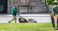 Municipal gardeners mowing the grass in the city center Royalty Free Stock Photo