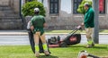 Municipal gardeners mowing the grass in the city center Royalty Free Stock Photo