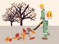 A municipal service worker removes autumn leaves with a vacuum cleaner.