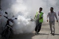 Municipal worker fogging in the market to fight dengue in Covid pandemic.