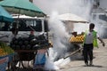 Municipal worker fogging in the market to fight dengue in Covid pandemic.