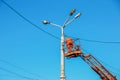 A municipal worker in protective equipment performs hazardous work to eliminate an interruption in the power grid. A worker