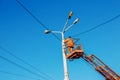 A municipal worker in protective equipment performs hazardous work to eliminate an interruption in the power grid. A worker