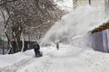 Municipal worker removing snow from the moscow street using snow blower Royalty Free Stock Photo