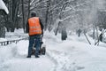 Municipal worker removing snow from the moscow street using snow blower Royalty Free Stock Photo