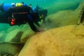 Munising, MI -August 14th, 2021: Two SCUBA divers cleaning an underwater toilet