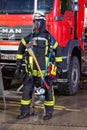 German fireman puppet stands near a fire engine on a presentation