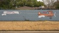 Mural on a barrier wall between Forest Lane and the neighborhood on the North side, painted in 1976 by art students.