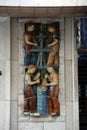 Mural ceramic reliefs depicting laborers and traditional local workers in Girona, Spain