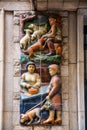 Mural ceramic reliefs depicting laborers and traditional local workers in Girona, Spain