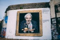Mural of David Attenborough holding an hourglass and a water bottle - plastic problem concept