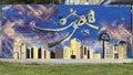 Mural by Dee on Trunk Street in Deep Ellum featuring Brad Oldham\'s Traveling Man Sculpture flying through the air.