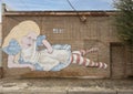 Mural featuring a frustrated Alice in Wonderland by artist Chaitra Linehan in Oak Cliff, Dallas, Texas.