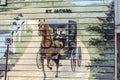 The mural of a Mennonite woman riding in a buggy on a wooden house wall. Royalty Free Stock Photo