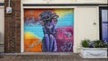 Mural painted on a pull down garage door featuring themes of confidence, power and self-love for women in Deep Ellum in Dallas.