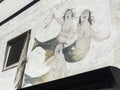 Three mermaids on a white wall