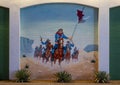 Mural with soldiers on horseback waving guns and riding through a desert on an outside wall of a shooting range in Dallas, Texas.